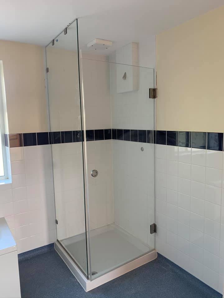 Frameless glass shower enclosure