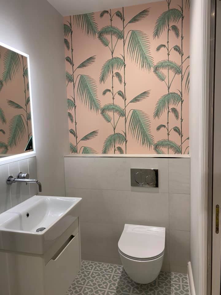 Cloakroom with palm print wallpaper, wall-hung toilet and basin